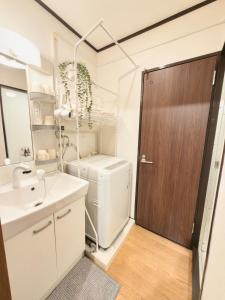 a bathroom with a toilet and a sink and a door at 久Hisashi 池下10号店 Nagoya in Nagoya