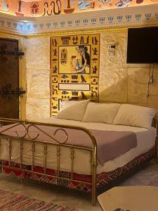 un letto in una stanza con un dipinto sul muro di Pyramids Mystery Inn a Il Cairo