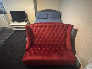a red couch in a room with a bed at Snug Studio - Minutes Walking from Pleasure Beach - Burlington Road in Blackpool