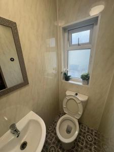 a bathroom with a toilet and a sink and a window at Snug Studio - Minutes Walking from Pleasure Beach - Burlington Road in Blackpool +3 photos