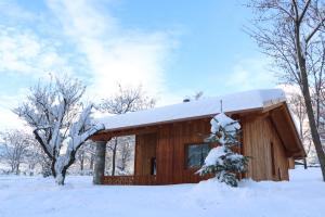 eine Blockhütte mit Schnee auf dem Dach in der Unterkunft Lazy Bee Camping Village in Aosta