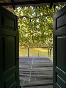 an open door to a deck with a body of water at Maligathenna in Nikawatawana