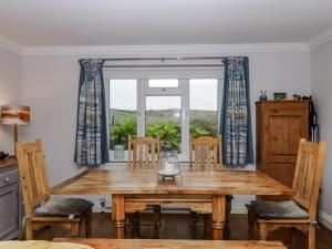 una sala da pranzo con tavolo in legno e finestra di 8 Thurlestone Rock a Hope Cove