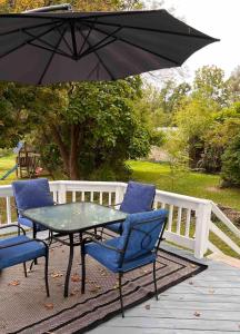 une table et des chaises sous un parasol sur une terrasse dans l'établissement Naples Wine Country 5BR Hot Tub Close to Bristol Mountain Skiing, à Naples