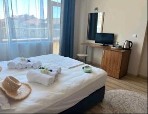 ein Hotelzimmer mit einem Bett mit Handtüchern darauf in der Unterkunft Къща за гости Беглик таш 3 in Primorsko