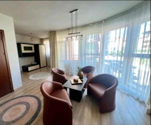 ein Wohnzimmer mit Stühlen, einem Tisch und einem Sofa in der Unterkunft Къща за гости Беглик таш 3 in Primorsko