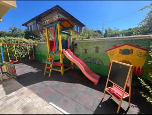 ein Spielbereich mit Rutsche und Spielplatz in der Unterkunft Къща за гости Беглик таш 3 in Primorsko