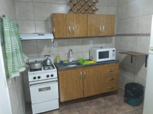 eine kleine Küche mit Herd und Mikrowelle in der Unterkunft Cabañas en Oliveros in Oliveros