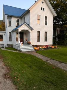 une maison blanche avec un toit bleu dans l'établissement Naples Wine Country 5BR Hot Tub Close to Bristol Mountain Skiing, à Naples