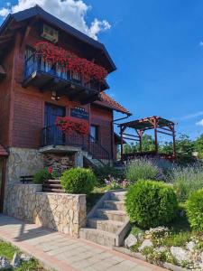 a wooden house with a balcony with red flowers at Rustic dream MIA in Zlatibor