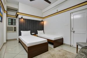 a bedroom with two beds and a window at Hotel Sukoon & Banquet Hall Near Bhopal Railway Station in Bhopal