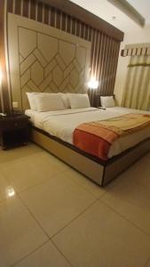 ein Schlafzimmer mit einem großen Bett in einem Zimmer in der Unterkunft Ambassador Inn in Islamabad