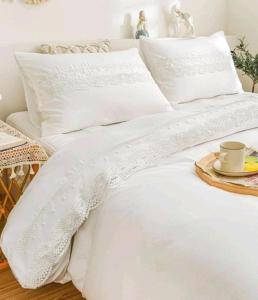 un letto bianco con un piatto e una tazza sopra di Tokyo downtown芍藥莊 a Tokyo