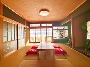 ein Wohnzimmer mit einem Tisch und roten Matten in der Unterkunft 瀬戸内庵Setouchian in Takamatsu