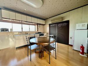 eine Küche mit Tisch und Stühlen und einem Kühlschrank in der Unterkunft 瀬戸内庵Setouchian in Takamatsu