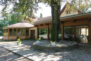 ein Haus mit einem Baum davor in der Unterkunft Villa Park Ustroń in Ustroń
