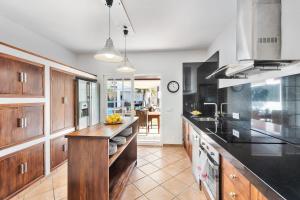 eine Küche mit Holzschränken und einer Arbeitsplatte in der Unterkunft Casa con piscina y gran jardín in Colònia de Sant Pere