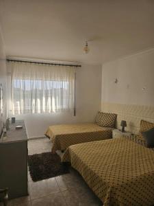 a hotel room with two beds and a window at Pedrogão Soul & Sunset in Pedrógão
