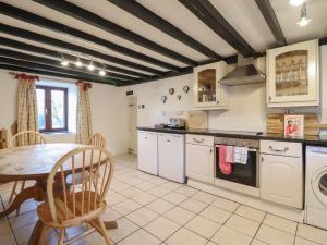 une cuisine avec une table et une salle à manger dans l'établissement 1 Fron Uchaf, à Frongoch