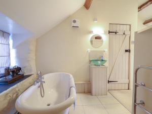 une salle de bain avec une baignoire et un lavabo dans l'établissement 1 Fron Uchaf, à Frongoch 30 autres photos