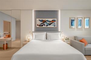 a bedroom with a large white bed and a couch at The Meydan Hotel Dubai in Dubai