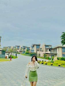 Eine Frau in einem grünen Rock, die auf einem Handy redet. in der Unterkunft Mysterio Luxury Villas - Private Pool in Cam Ranh