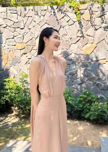 Eine Frau in einem rosa Kleid steht vor einer Steinmauer in der Unterkunft Mysterio Luxury Villas - Private Pool in Cam Ranh