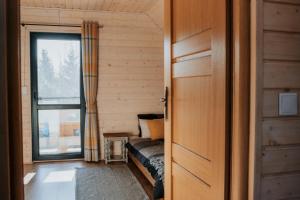 ein kleines Zimmer mit einem Sofa und einem Fenster in der Unterkunft Domek nad Jeziorem Bogaczewo in Bogaczewo