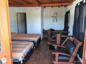ein Zimmer mit 2 Betten und einem Stuhl darin in der Unterkunft Cabaña Anisacate in Villa Anizacate