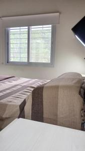 En eller flere senge i et værelse på Chalet Arredondo Villa Carlos Paz