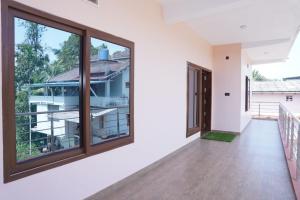 an empty room with large windows and a balcony at SringeriRooms- Shakthi Homestay in Sringeri