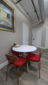 a dining room with a white table and red chairs at The Downtown Gem Toronto in Toronto