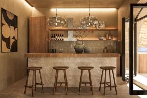 une cuisine avec un bar avec quatre tabourets dans l'établissement Villa Lavender by Villa Plus, à Kolimbia