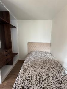 une petite chambre avec un lit et une commode dans l'établissement Le 1000 fleurs studio neuf à 3 kms de La Rochelle, à Nieul-sur-Mer