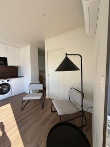 - un salon avec deux chaises et une lampe dans l'établissement Le 1000 fleurs studio neuf à 3 kms de La Rochelle, à Nieul-sur-Mer