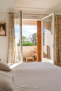 ein Schlafzimmer mit einem großen Bett und einer Glasschiebetür in der Unterkunft Provencal Villa Near Montpellier in Castelnau-le-Lez