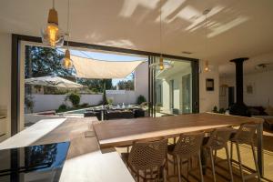 ein Esszimmer mit einem großen Holztisch und Stühlen in der Unterkunft Modern Villa With Pool In Castelnau-Le-Lez in Castelnau-le-Lez