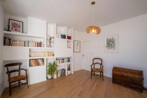 ein Wohnzimmer mit 2 Stühlen und Bücherregalen in der Unterkunft Modern Villa With Pool In Castelnau-Le-Lez in Castelnau-le-Lez