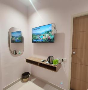 Un baño con un televisor en la pared y una encimera. en Elegant Residency, en Coimbatore