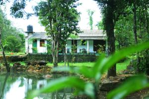 a house with a pond in front of it at Ranpokuna Bungalow with 3 Bed Rooms in Kiriella