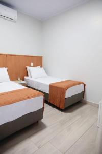 a hotel room with two beds in a room at Pousada Encantos de Itá in Itá