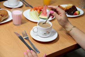 a person is stirring a cup of coffee on a table at Pousada Encantos de Itá in Itá +10 photos