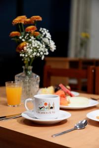 a table with a cup of coffee and a plate of food at Pousada Encantos de Itá in Itá