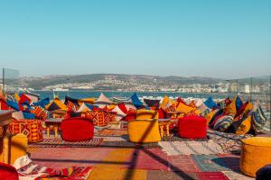 um grupo de cadeiras e mesas coloridas num pátio em Riad Dar Chams Tanja em Tânger