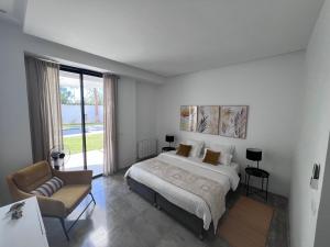 a white bedroom with a bed and a couch at Dar El Musc Chambres d'hôtes in Sukrah +23 photos
