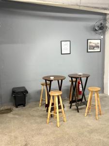 um conjunto de mesas e bancos encostados em uma parede em Downtown Santana Hotel no Rio de Janeiro