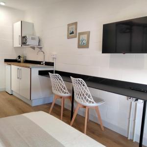 a kitchen with two chairs and a tv on the wall at Visitar La Campana in La Campana