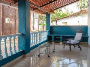 AgarvadoAbigail serene stay的门廊上摆着一把椅子和一条长凳，墙是蓝色的。