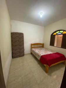 ein kleines Schlafzimmer mit einem Bett und einem Fenster in der Unterkunft Nataliana's House in Cabo Frio