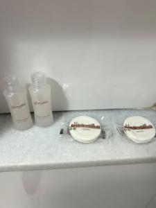uma bancada com dois frascos de sabonete e um prato em Downtown Santana Hotel no Rio de Janeiro